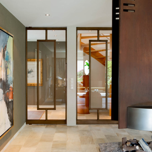 Design bronzen stalen taatsdeur met glas, geïntegreerd in een warm en luxe interieur.